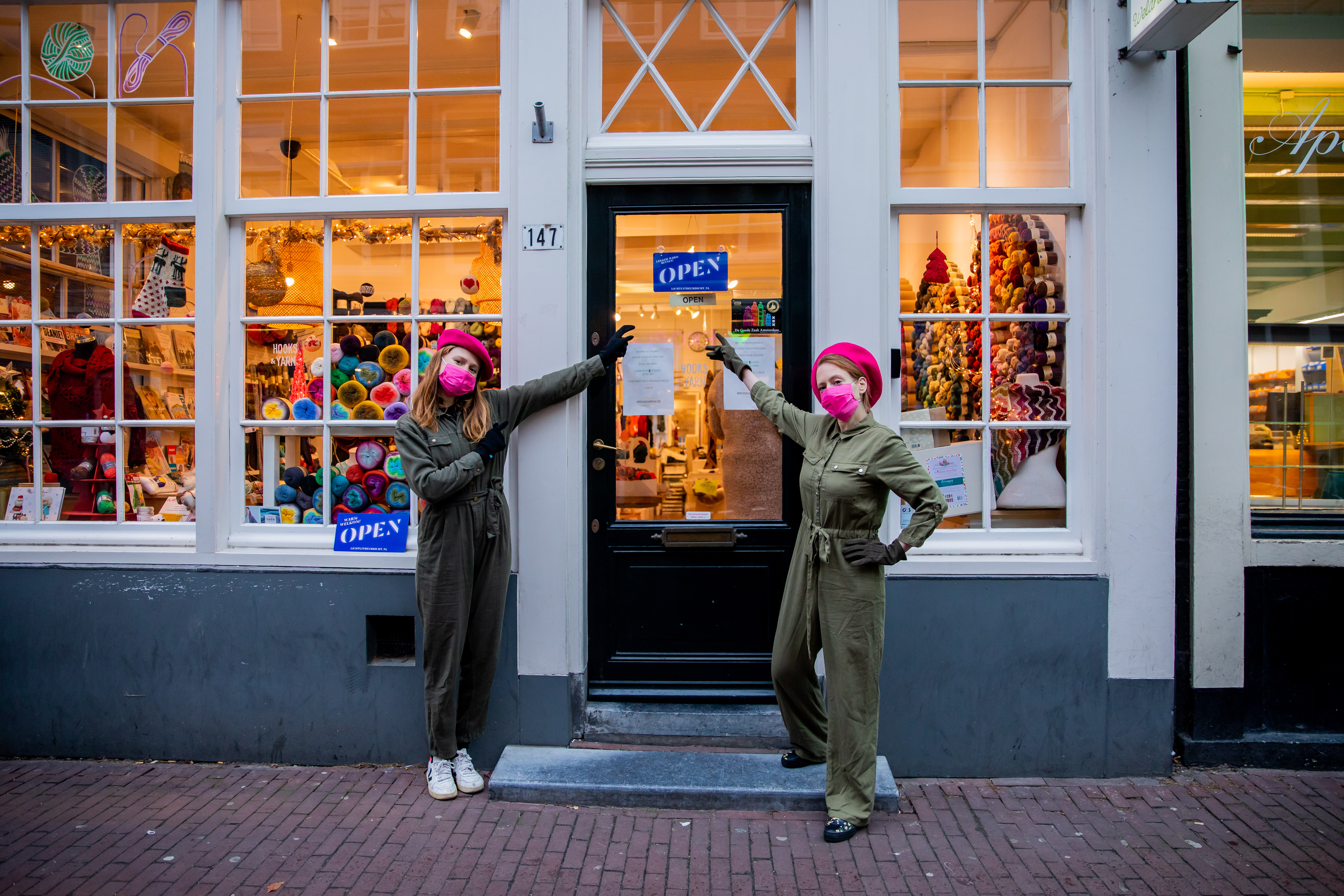 StoereVrouwen delen winkeldeurbordjes uit in Amsterdam